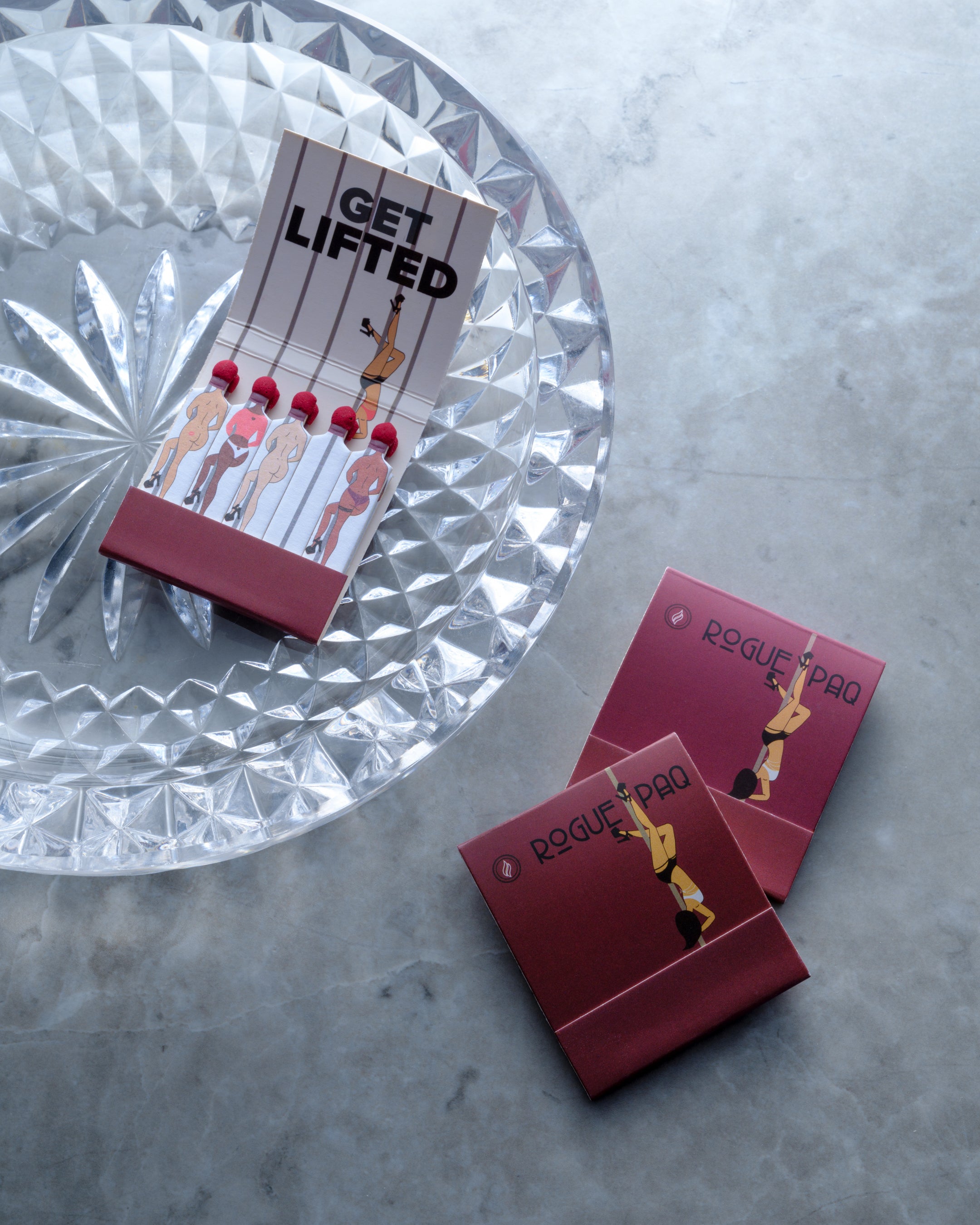Get Lifted vintage-style matchbooks styled with a crystal ashtray; functional coffee table decor that adds a playful touch to a luxury smoking session
