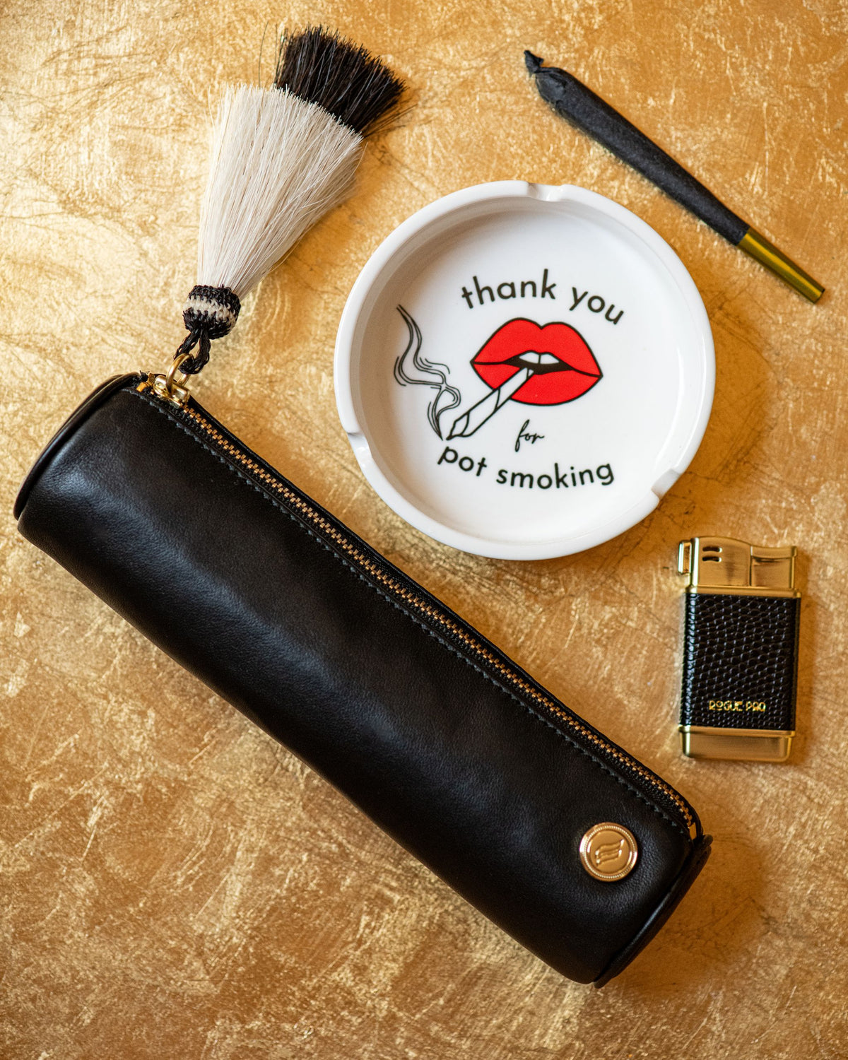 White porcelain cannabis ashtray featuring "Thank You For Pot Smoking" graphic in red and black, designed like a vintage hotel ashtray with nostalgic vibes to raise your ritual. Styled with our Solo Paq, refillable lighter and hemp cone.