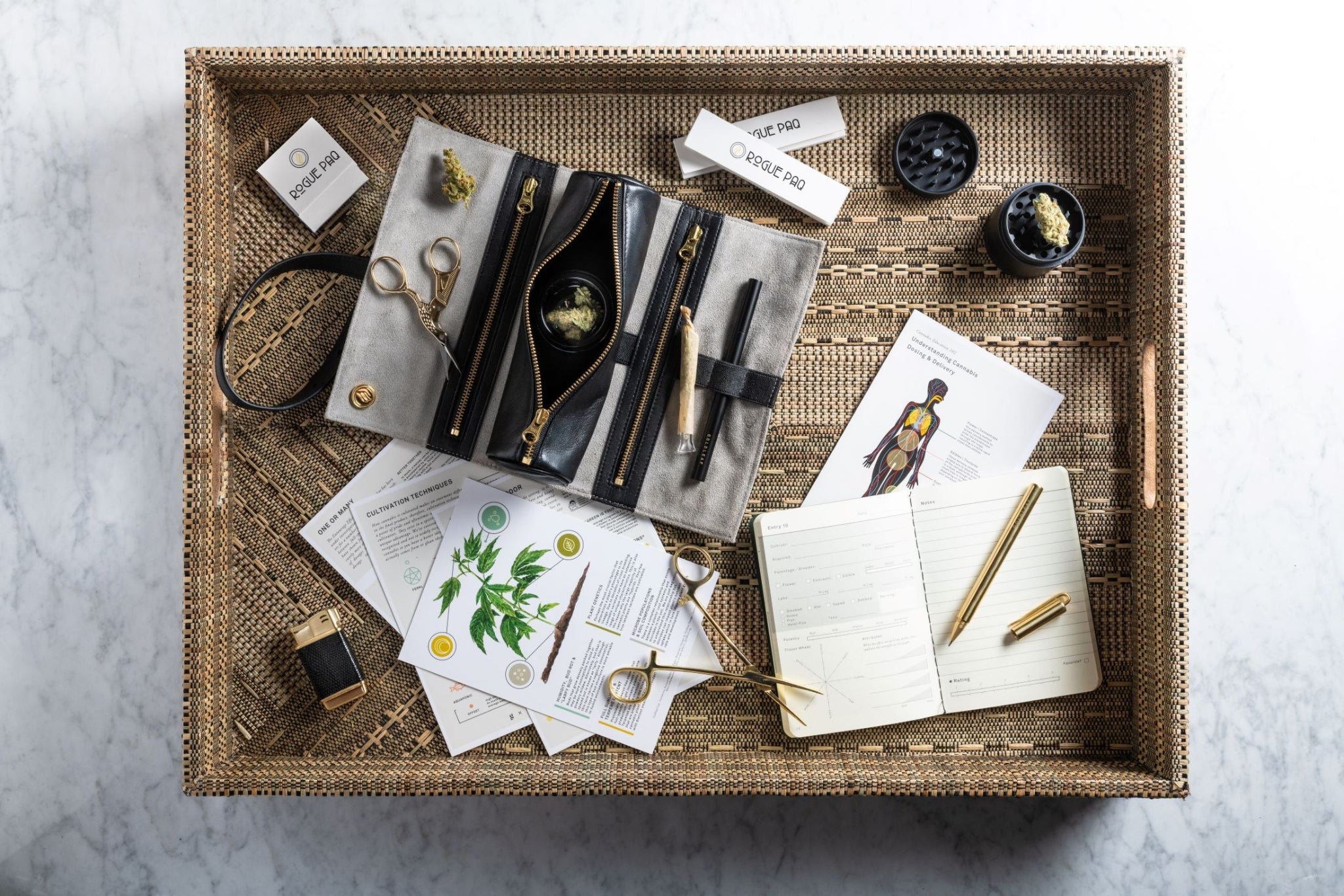 Complete collection of Rogue Paq accessories including SendNudes matches, rolling papers, and grease pencil; the 'presidential suite' of smoking accessories for the modern connoisseur. The collection is arranged to showcase a complete, elevated cannabis ritual system.