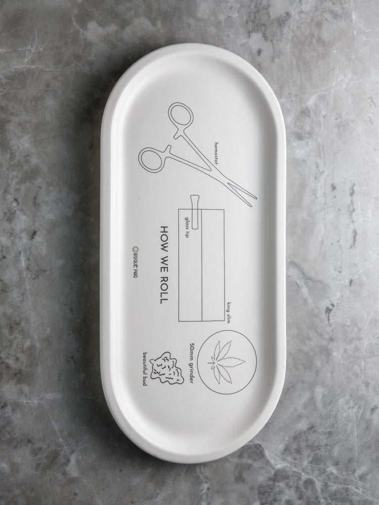 Rogue Paq 'How We Roll' porcelain valet tray featuring instructional joint rolling illustrations; a functional and artistic centerpiece for the modern cannabis ritual.