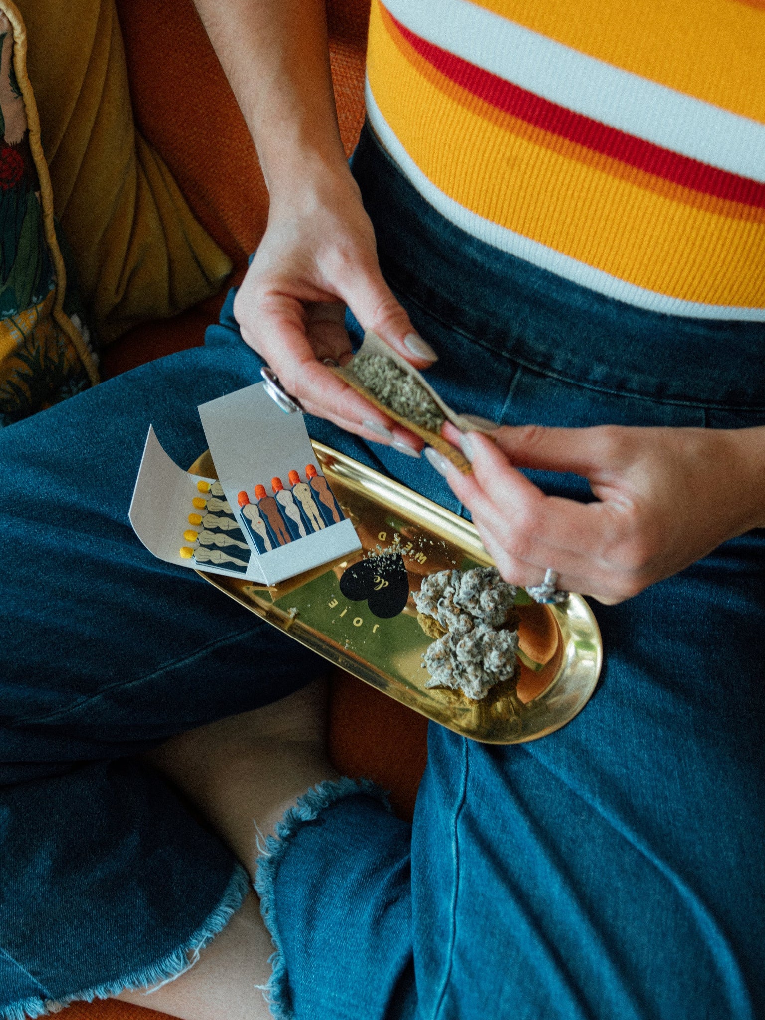 The Joie de Weed rolling tray in use, showing its perfect scale for rolling a joint. The smooth stainless steel surface and slightly curved edges are designed for ease of use, ensuring no flower is wasted during the ritual.