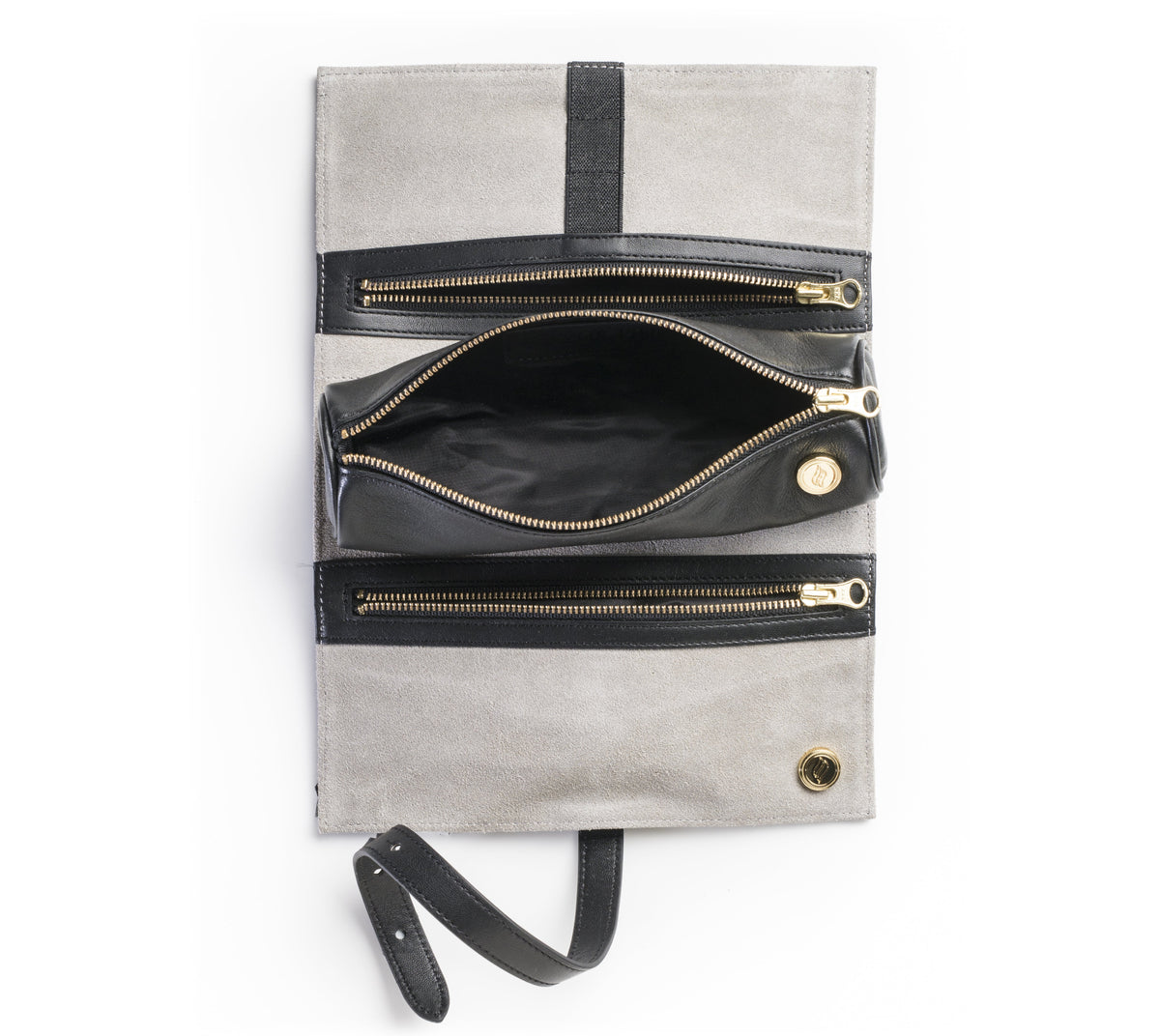 A top-down view of the unrolled black leather Ritual Case. The interior features a luxurious steel gray suede lining with specialized elastic loops holding gold-toned tools, alongside a removable magnetic storage pouch and deep zippered pockets. In this shot the pop out pouch is open to show its capacity for storage.