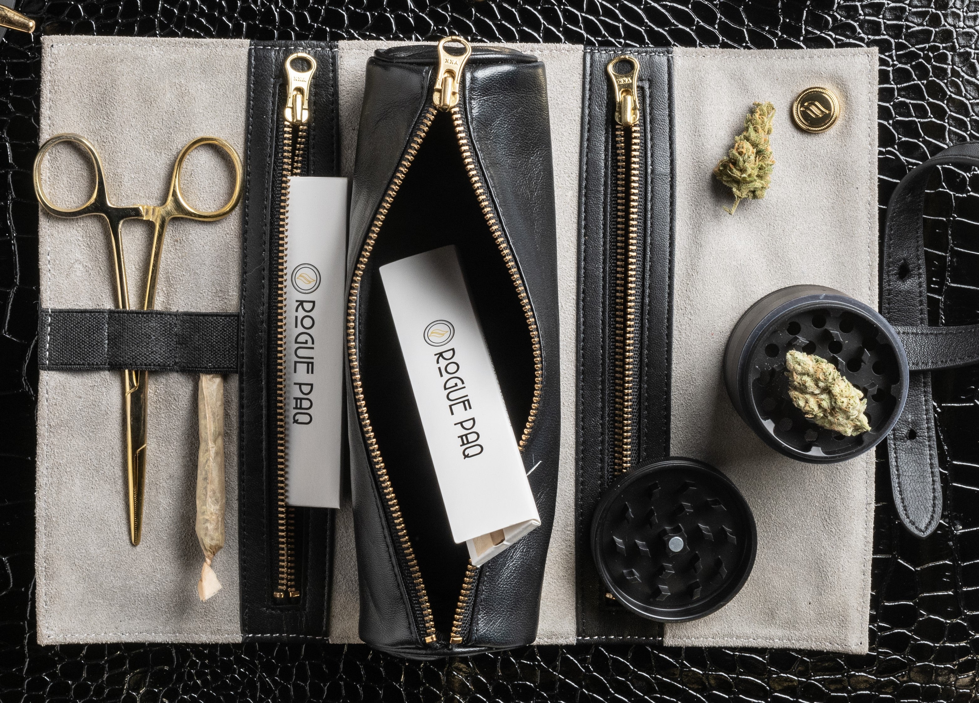 A Rogue Paq rolling paper booklet tucked into the specialized internal pop out pouxh of a Rogue Paq leather Ritual Case. This illustrates the seamless organization and portability of the brand's luxury cannabis accessory system.