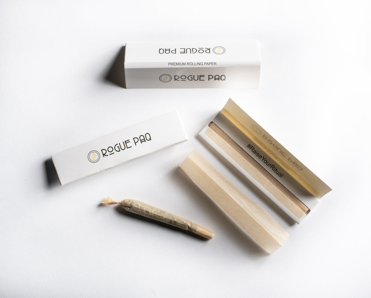 A close-up of a perfectly hand-rolled joint using Rogue Paq King Slim papers. The translucent quality of the thin unbleached hemp allows the flower to be subtly seen, emphasizing a clean and flavor-focused burn.