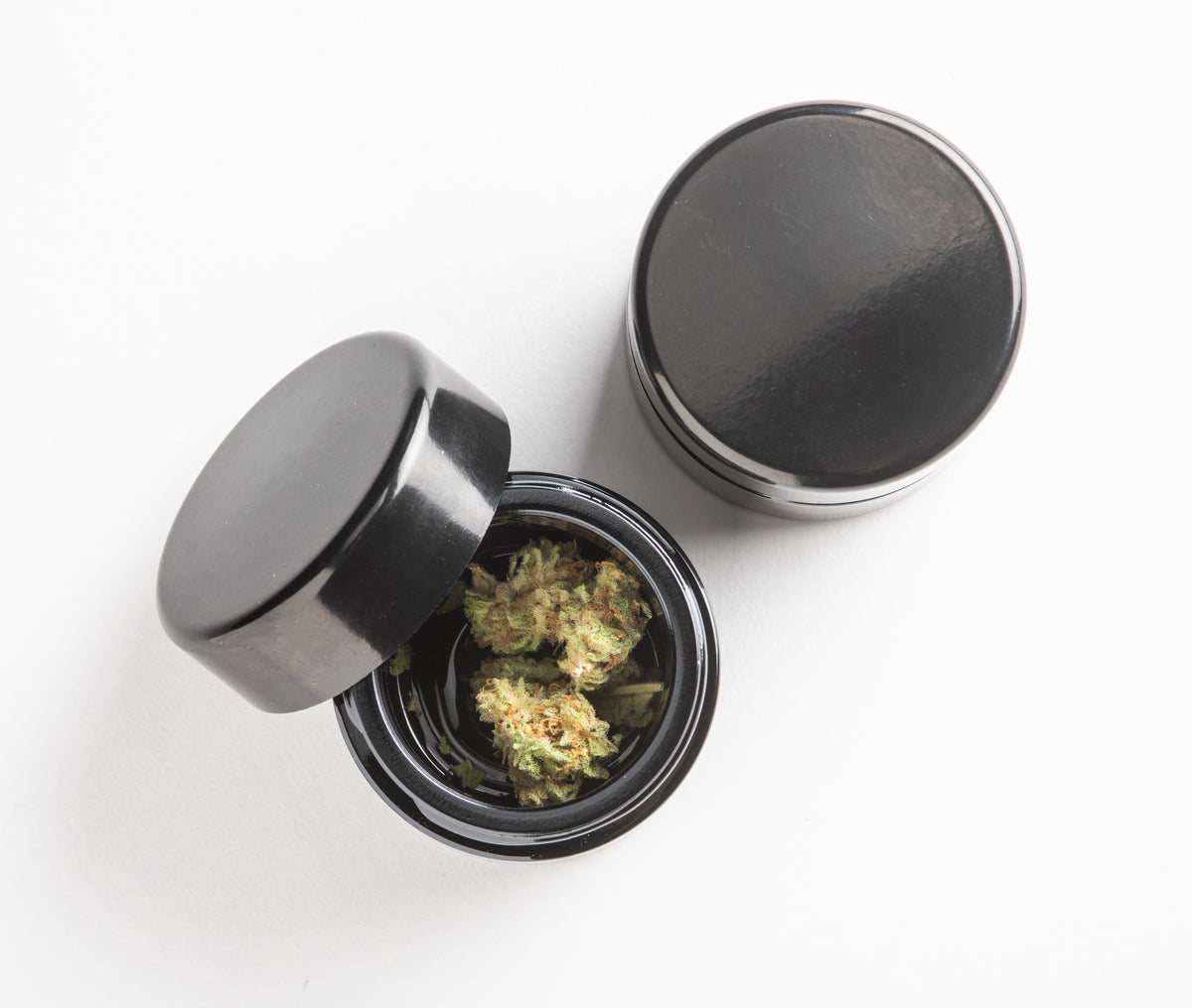 The 1oz glass jar featured open and on a clean white surface demonstrates its compact, travel-friendly scale. The sleek, monolithic design is discreet and fits perfectly into the pop our pouch of a Rogue Paq Ritual Case.