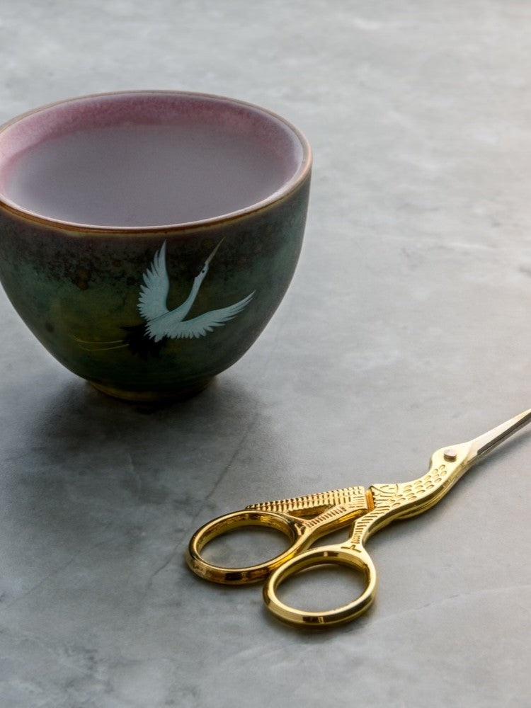 Rogue Paq Crane Manual-Grind Bud Snipping Set featuring gold-tone crane scissors and a stoneware ceramic cup; an elegant alternative to traditional grinders for a mindful cannabis ritual.
