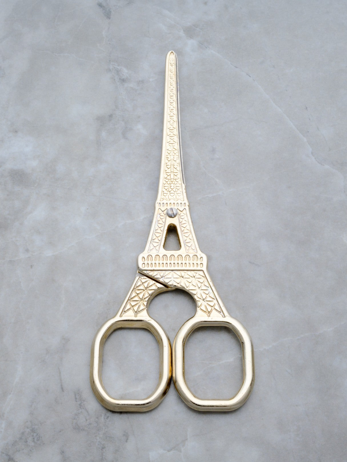 Rogue Paq gold cannabis trimming scissors in the shape of the Eiffel Tower for a refined smoking ritual.