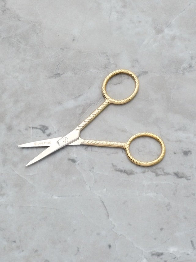 Rogue Paq Ribbon-Wrapped Scissors in gold-tone stainless steel; featuring intricate ribbon-motif handles for a sophisticated and precise cannabis trimming ritual
