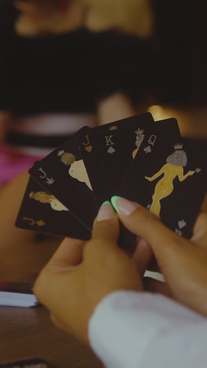 Hands holding a winning hand of Rogue Paq Get Lucky playing cards; showcasing the gold foil edges and luxury aesthetic perfect for an elevated poker night.