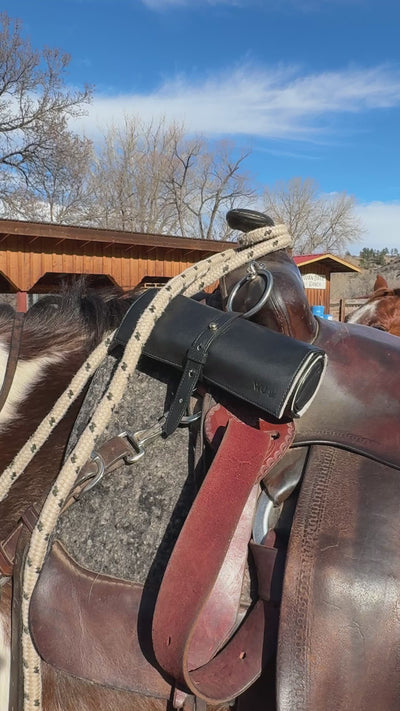 short video of the Rogue Paq Ritual Case in lambskin leather strapped to a horse's saddle's pommel. This highlights the case's durability and its heritage as a modern, luxury version of a traditional tool roll.