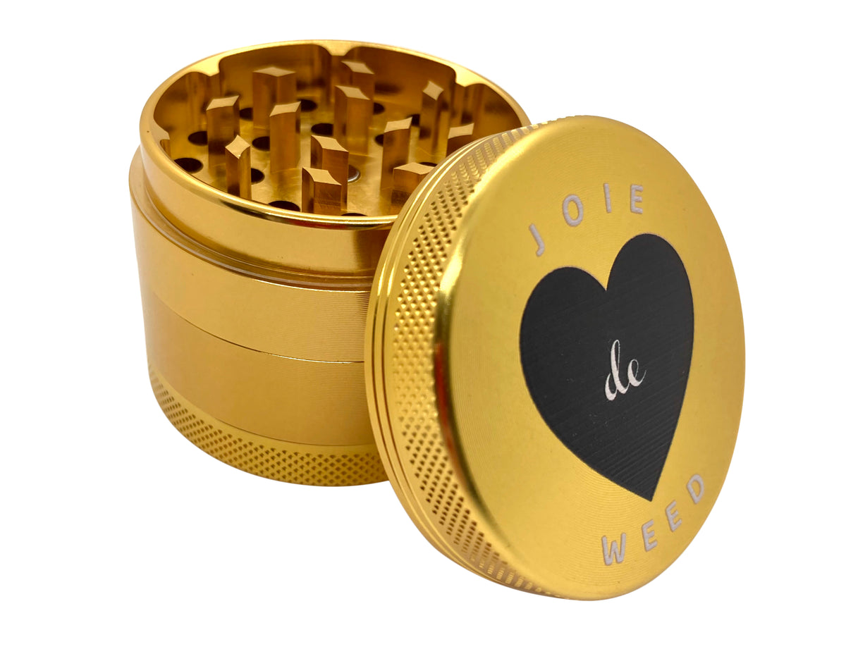 Side profile of the 50mm Joie de Weed grinder, highlighting the t.extured, knurled grip on the top and bottom sections. The design provides maximum torque and comfort for a seamless grind, maintaining a sleek, monolithic silhouette. Perfect if you like cute smoking accessories.