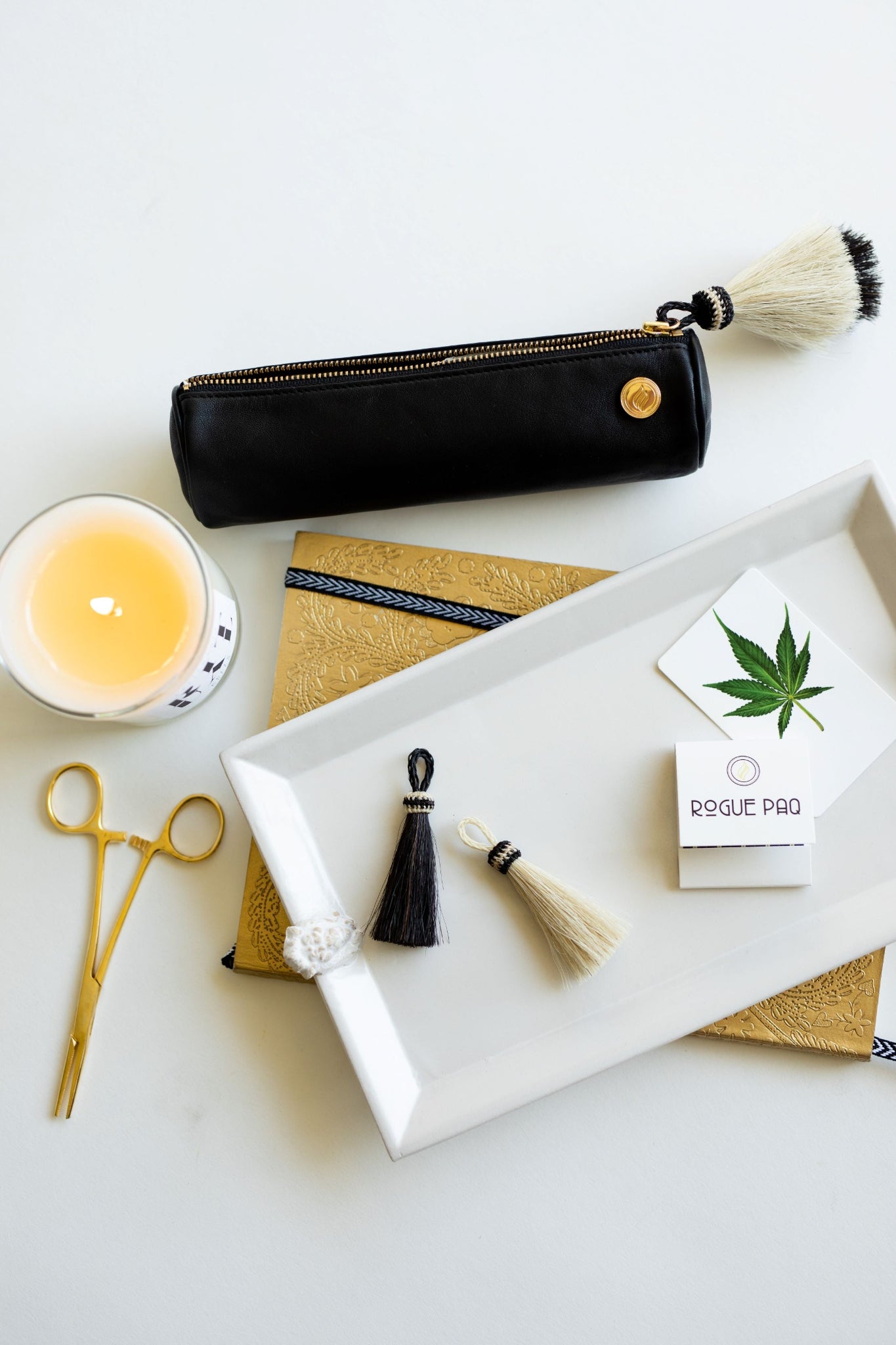 Solo Paq with Hemostat Joint Clip on a clean white background  along with other Rogue Paq luxury tools for a high end luxury cannabis smoke session.