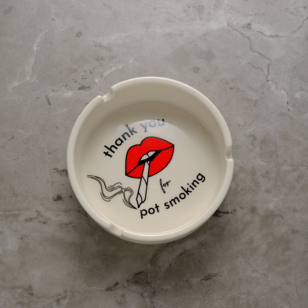 White porcelain cannabis ashtray featuring "Thank You For Pot Smoking" graphic in red and gold, designed like a vintage hotel ashtray.